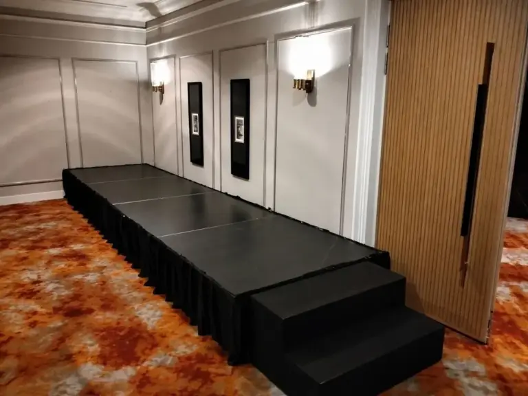 Long black platform stage with black skirting and steps in a hotel function room in Singapore