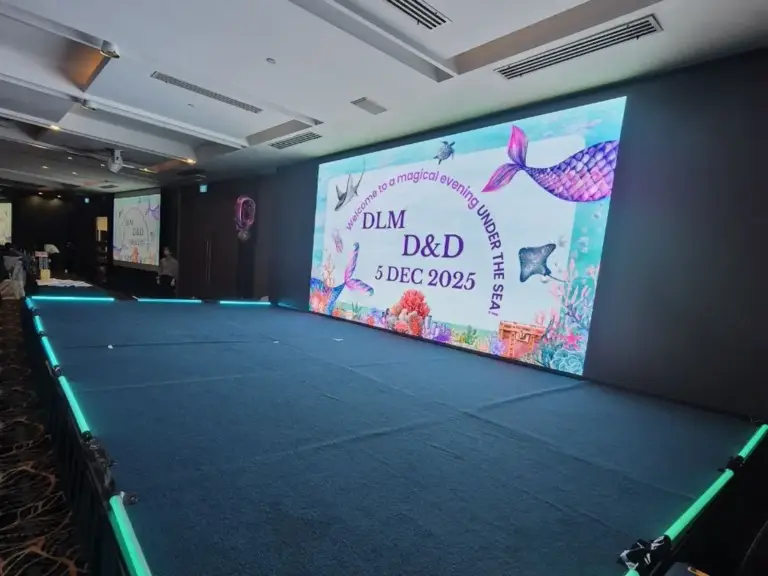 Carpeted platform stage with LED edge lighting in front of an LED wall at a dinner and dance in Singapore