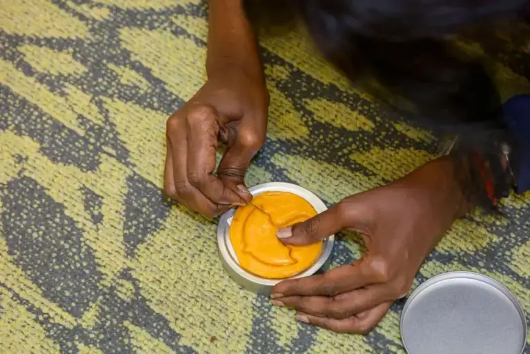 Participant carving a shape from a honeycomb candy in a team building challenge in Singapore