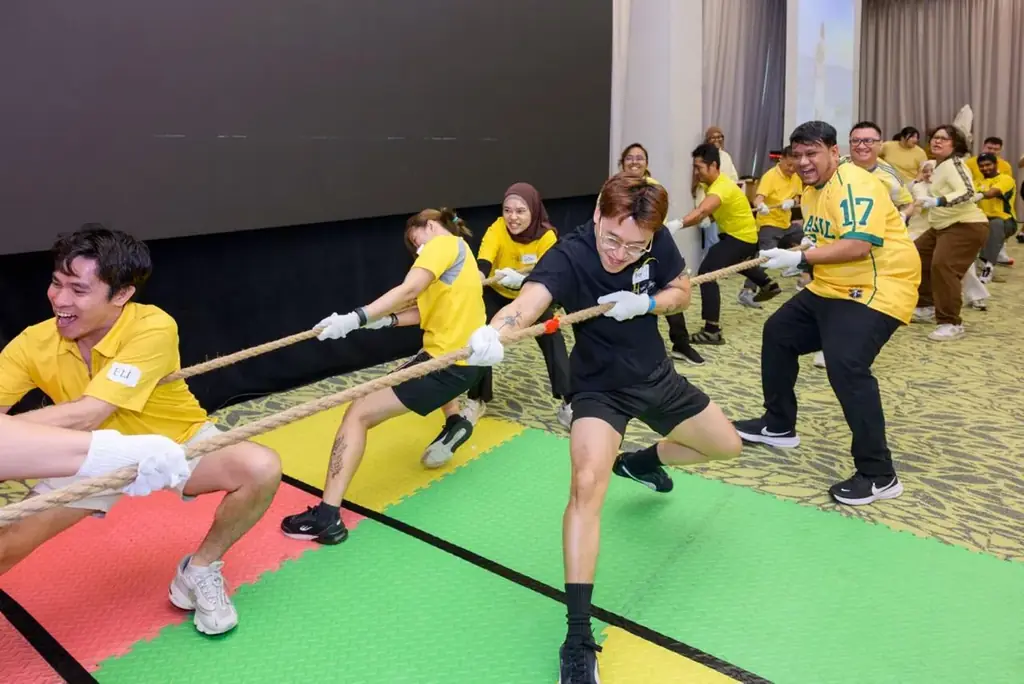 Colleagues pulling in an indoor tug of war round on padded mats in Singapore