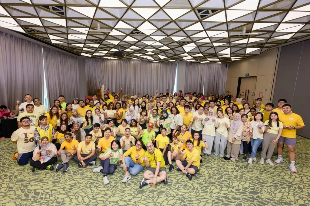Large corporate group in yellow dress code after an indoor team building day in Singapore